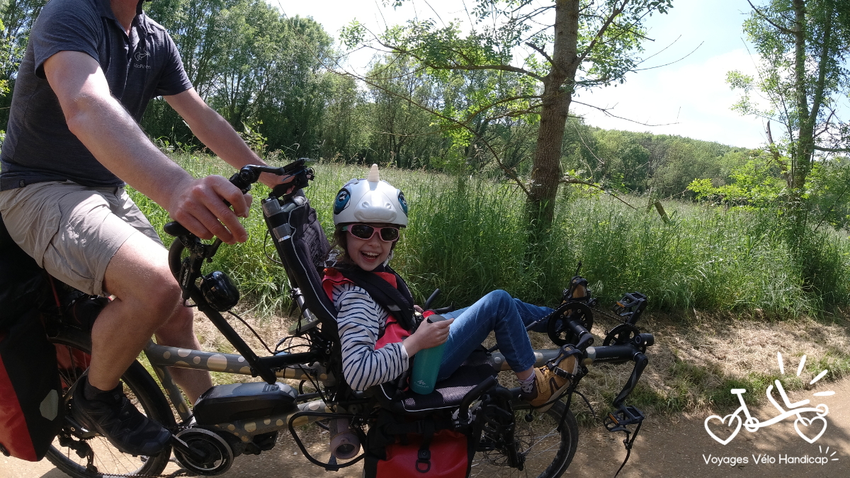 Une jeune fille en situation de handicap heureuse sur son tandem Pino Locapino
